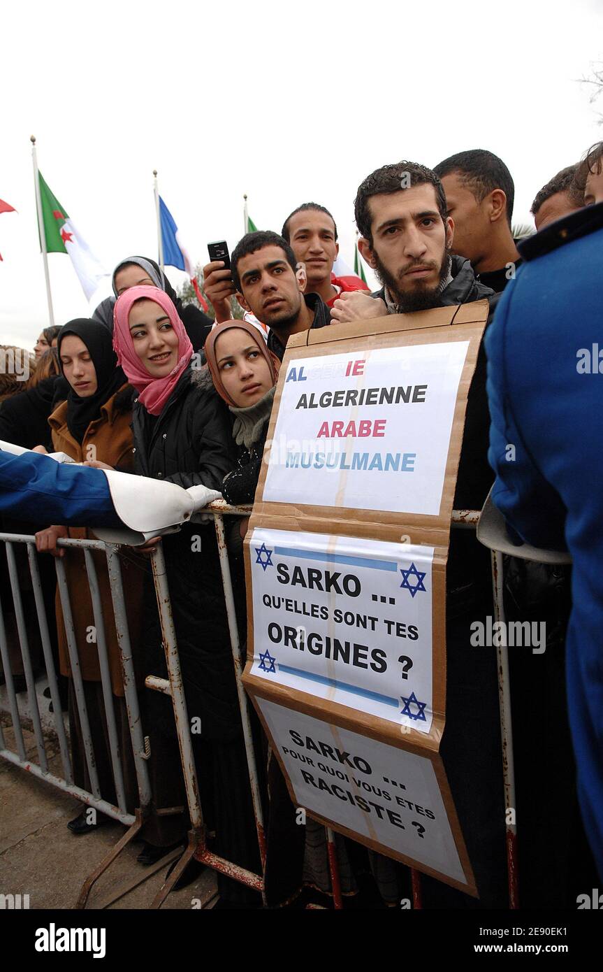 Uno studente che porta un cartello si oppone alle barriere mobili e mantiene la folla mentre il presidente francese Nicolas Sarkozy e il presidente algerino Abdelaziz Bouteflika (off) stringono le mani con gli studenti al di fuori dell'università di Mentouri durante l'ultimo giorno della visita del presidente francese in Algeria, 05 dicembre 2007. Foto di Christophe Guibbaud/ABACAPRESS.COM didascalia locale Foto Stock