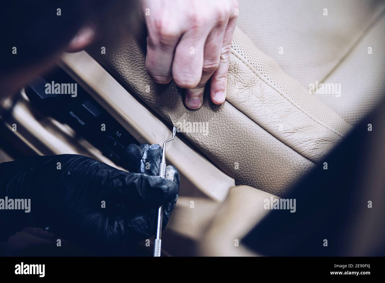 Lavoro in studio di ristrutturazione che rinnova il sedile in pelle per auto Foto Stock