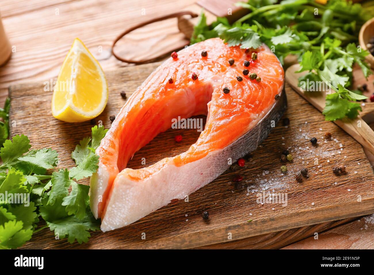 Bistecca di salmone crudo, spezie ed erbe su sfondo di legno Foto Stock