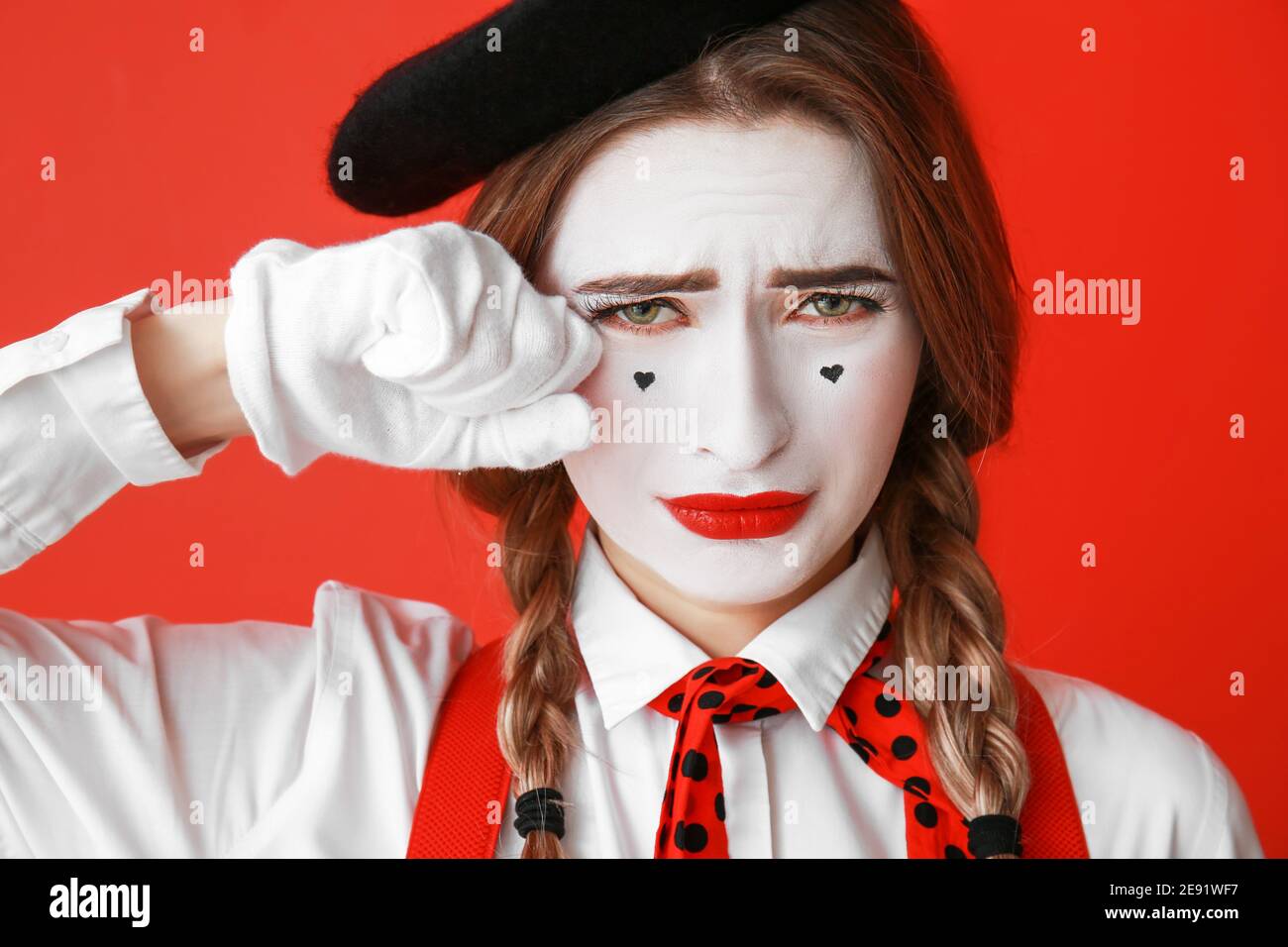 Pantomimista femminile pianto su sfondo colorato Foto Stock