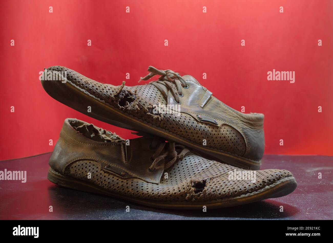 Vecchie scarpe estive gialle lacerate su sfondo rosso e nero. Due scarpe da  uomo in pelle molto indossate. Messa a fuoco selettiva Foto stock - Alamy