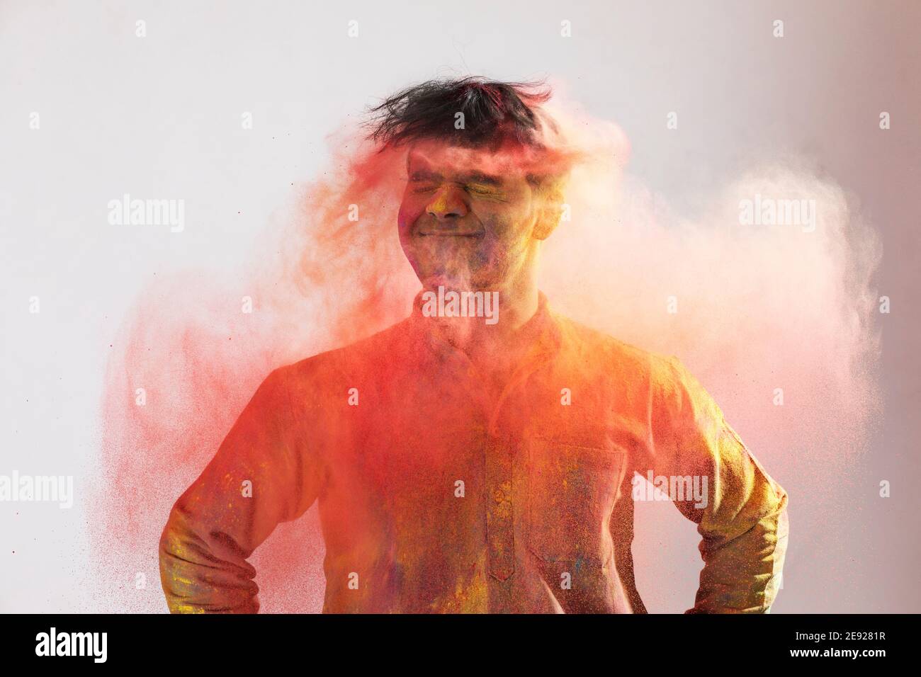 Giovane uomo scuotendo la testa piena di colori Foto Stock