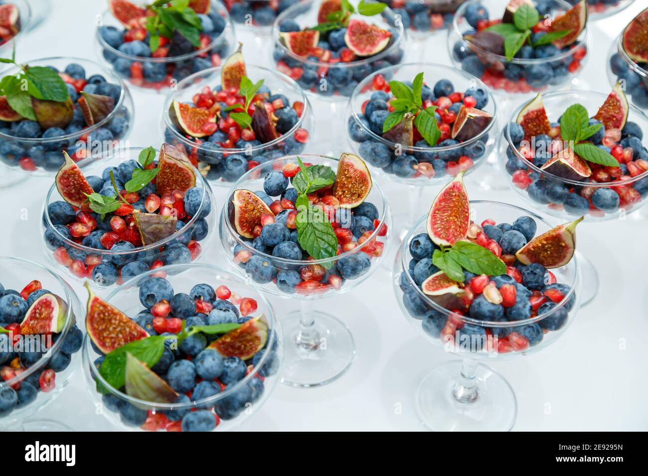 Lamponi, more e mirtilli. In un piatto di vetro ci sono delle bacche meravigliose e deliziose. Cibo sano e sano Foto Stock