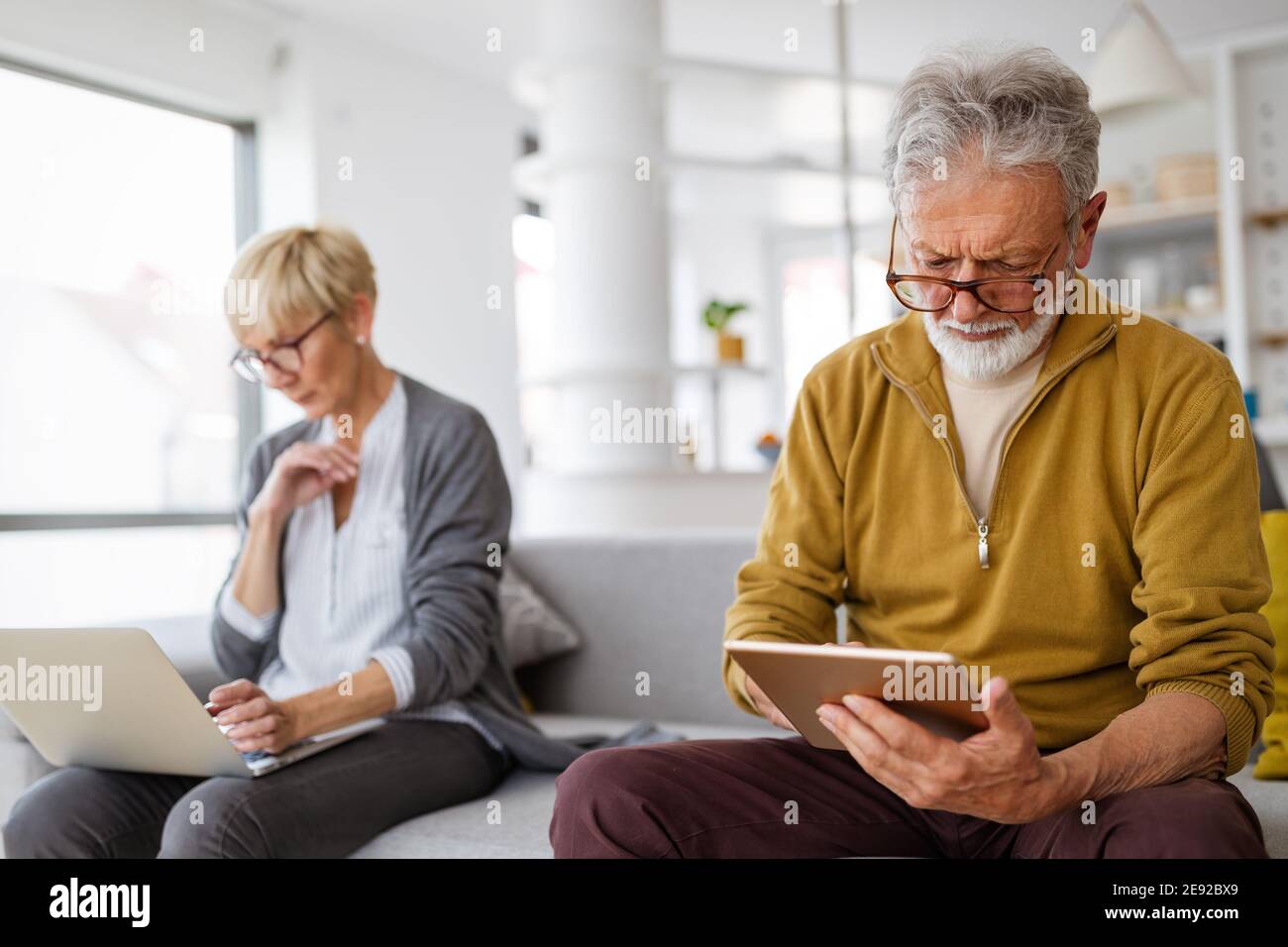 Coppia senior che ha problemi con i dispositivi tecnologici a casa Foto Stock