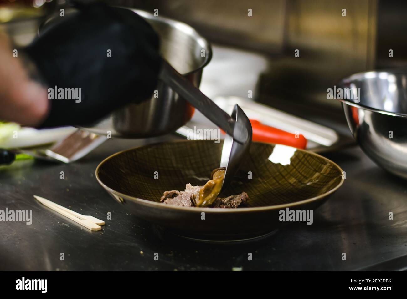 Chef che prepara zuppa di noodle ramen con carne, uova e verdure in un ristorante Foto Stock