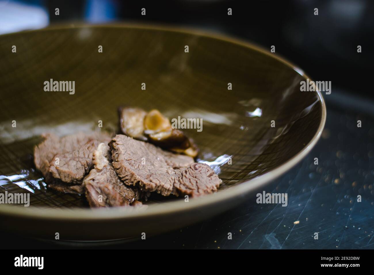 Chef che prepara zuppa di noodle ramen con carne, uova e verdure in un ristorante Foto Stock