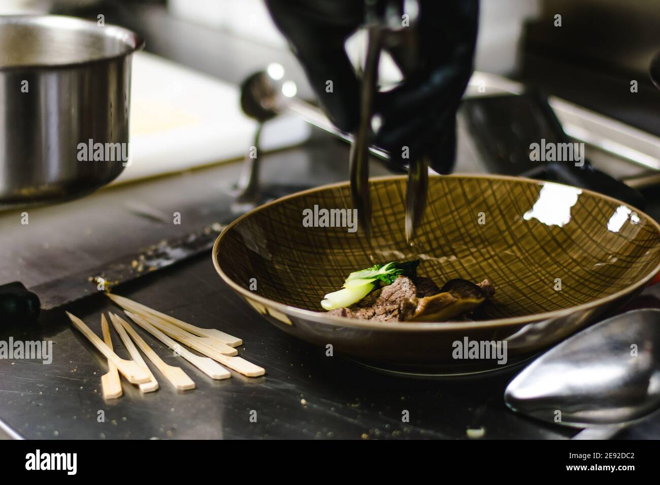 Chef che prepara zuppa di noodle ramen con carne, uova e verdure in un ristorante Foto Stock