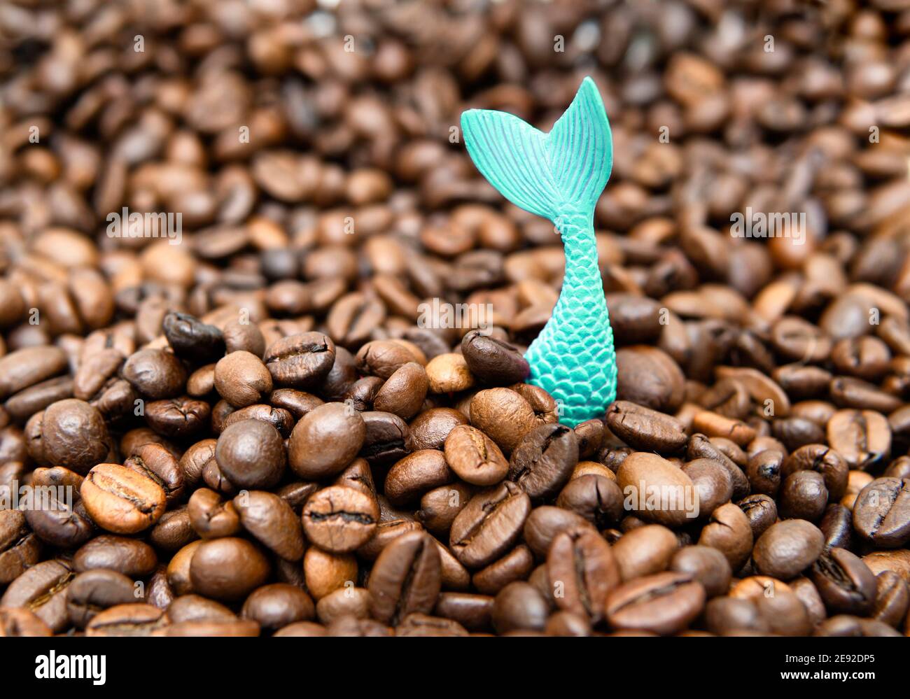 La coda della sirena giocattolo si stacca da un mucchio di arrosto chicchi di caffè Foto Stock