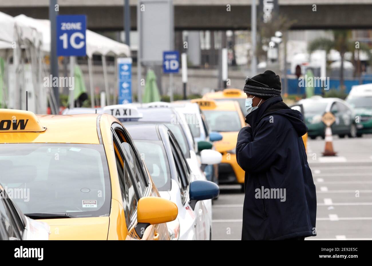 (210202) -- LOS ANGELES, 2 febbraio 2021 (Xinhua) -- UN tassista che indossa una maschera attende i clienti all'aeroporto internazionale di Los Angeles, California, Stati Uniti, il 1 febbraio 2021. A partire da martedì, gli americani sono tenuti a indossare maschere facciali mentre viaggiano sui trasporti pubblici nazionali come parte di una strategia nazionale per limitare la diffusione del COVID-19. La regola, emessa dai Centri statunitensi per il controllo e la prevenzione delle malattie (CDC), si applica ai passeggeri su aerei, treni, metropolitane, autobus, taxi e ride-share. E si estende ad aree di attesa come aeroporti, piattaforme ferroviarie e. Foto Stock