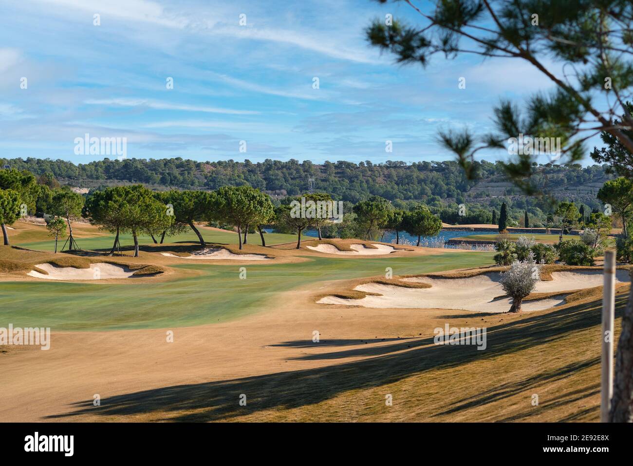 Pittoresco scenario campo da golf campo verde con alberi e lago blu durante caldo inverno soleggiato giorno, prato situato a Las Colinas. Provincia di Alicante Foto Stock