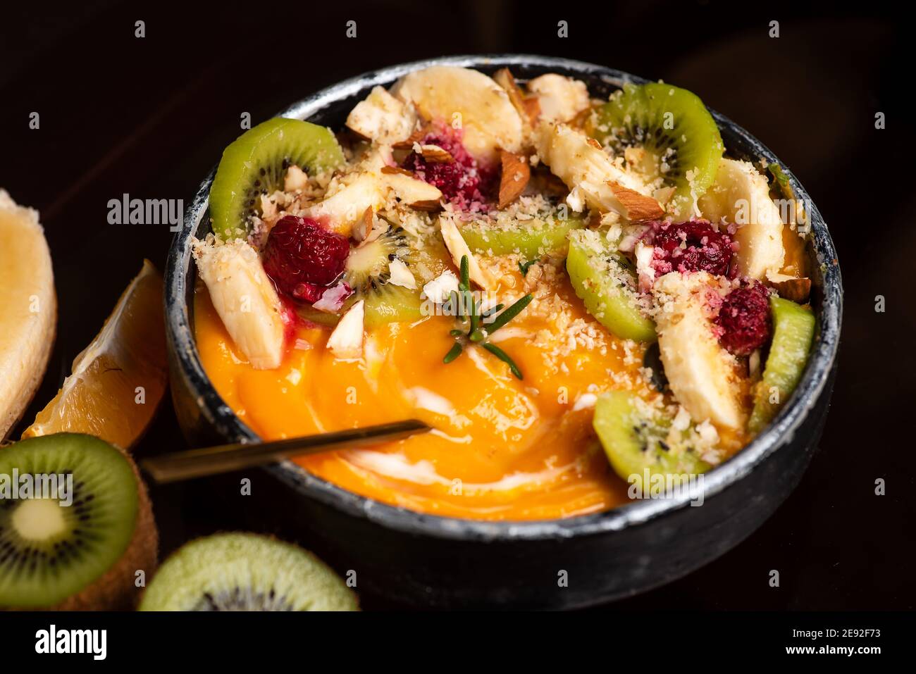 Zuppa di zucca in una ciotola con agrumi su a. impostazione rustica con ingredienti alimentari Foto Stock