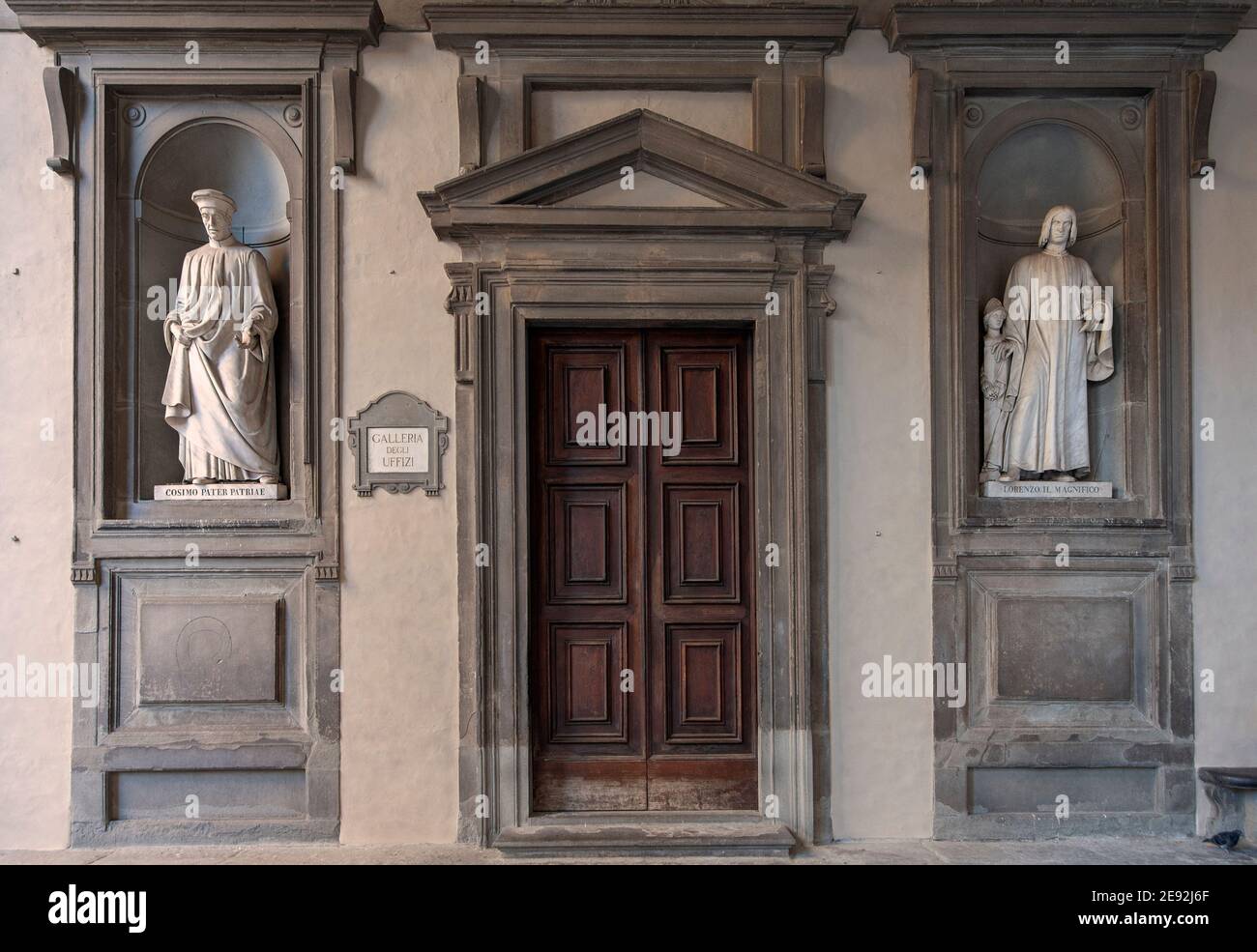 Firenze, Italia - 2020 gennaio 18: Antica porta d'ingresso in legno al Museo della Galleria degli Uffizi. Statue di marmo di Cosimo e Lorenzo Medici su entrambi i lati. Foto Stock