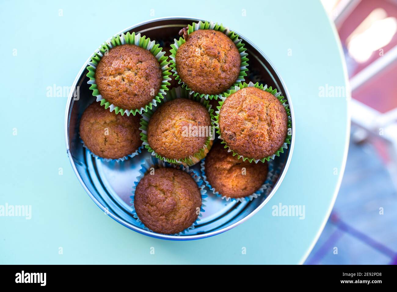 Muffin con involucri collocati in una scatola di metallo su un tavola verde Foto Stock