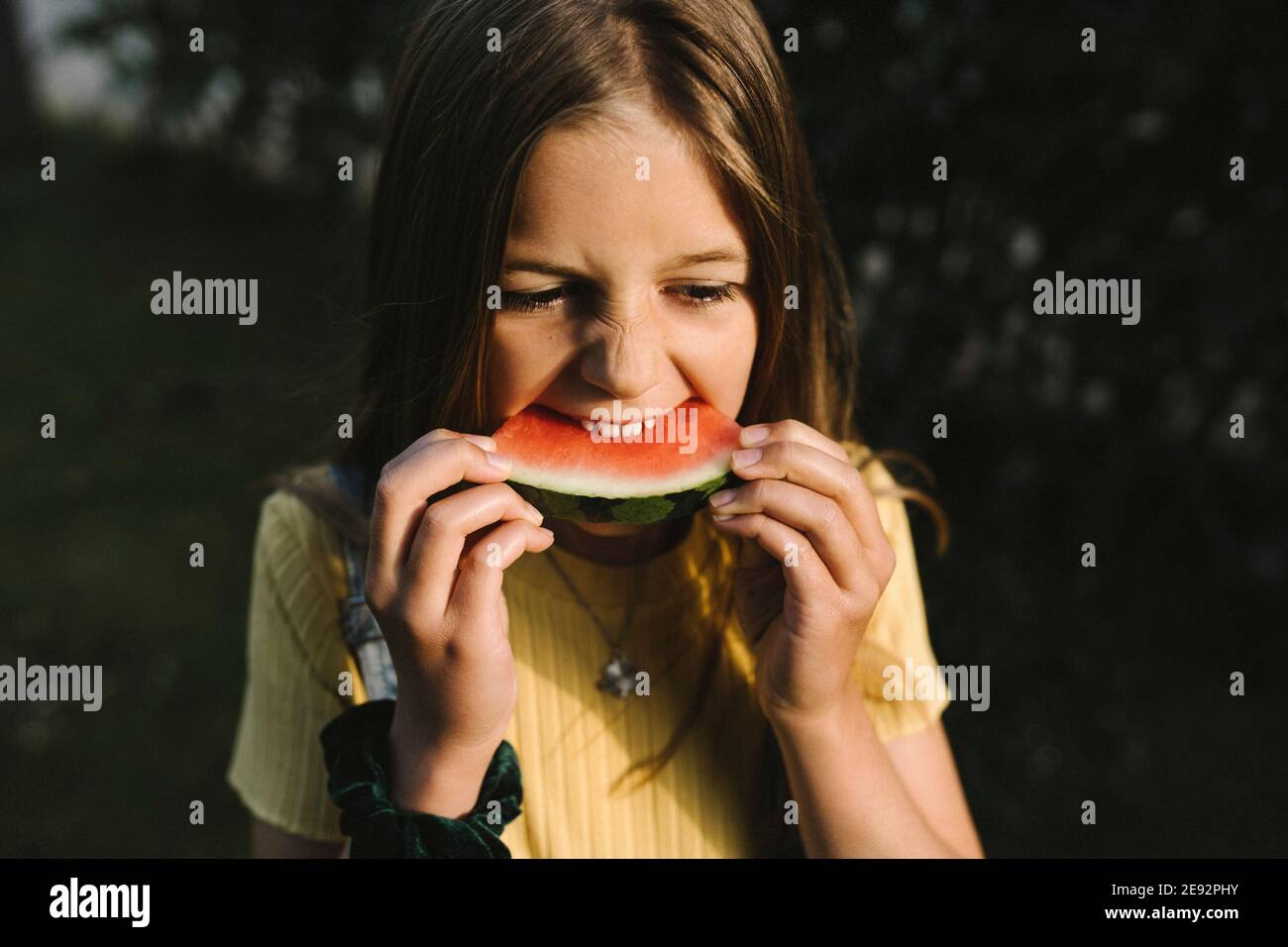 Ragazza che mangia l'anguria il giorno di sole Foto Stock