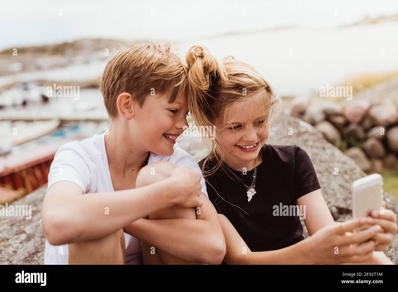 Sorridi fratello e sorella prendendo selfie su smartphone a. marina Foto Stock