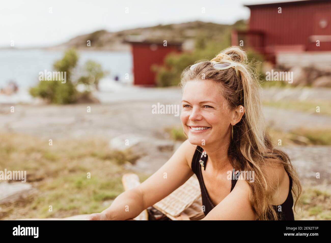 Donna sorridente che guarda via durante il picnic al porto Foto Stock