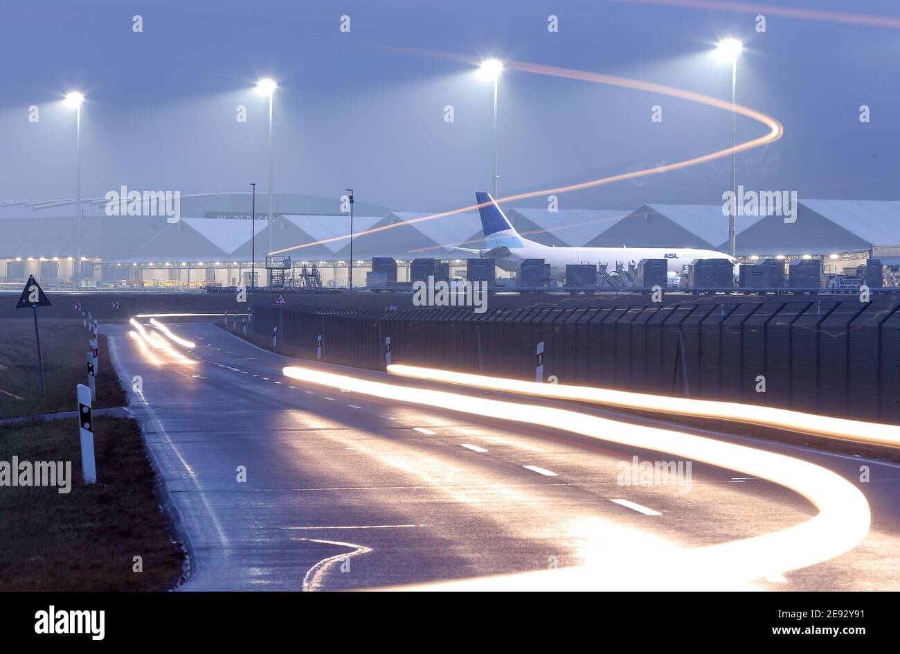 Sassonia, Schkeuditz, 02 febbraio 2021: Le auto attraversano i terreni dell'aeroporto di Lipsia/Halle. L'aeroporto continua a diventare uno dei più importanti centri di trasporto aereo in Europa. Anche se il volume dei passeggeri è diminuito, soprattutto a causa della pandemia di Corona, il volume di merci è aumentato in modo significativo: Nel 2020, è aumentato del 11.7%, raggiungendo appena meno di 1.4 milioni di tonnellate. Solo a dicembre, il trasporto aereo è aumentato del 35%. Grazie a una speciale certificazione, i prodotti farmaceutici sensibili possono essere trattati anche in aeroporto, che potrebbe quindi svolgere un ruolo importante nella gestione di Co Foto Stock