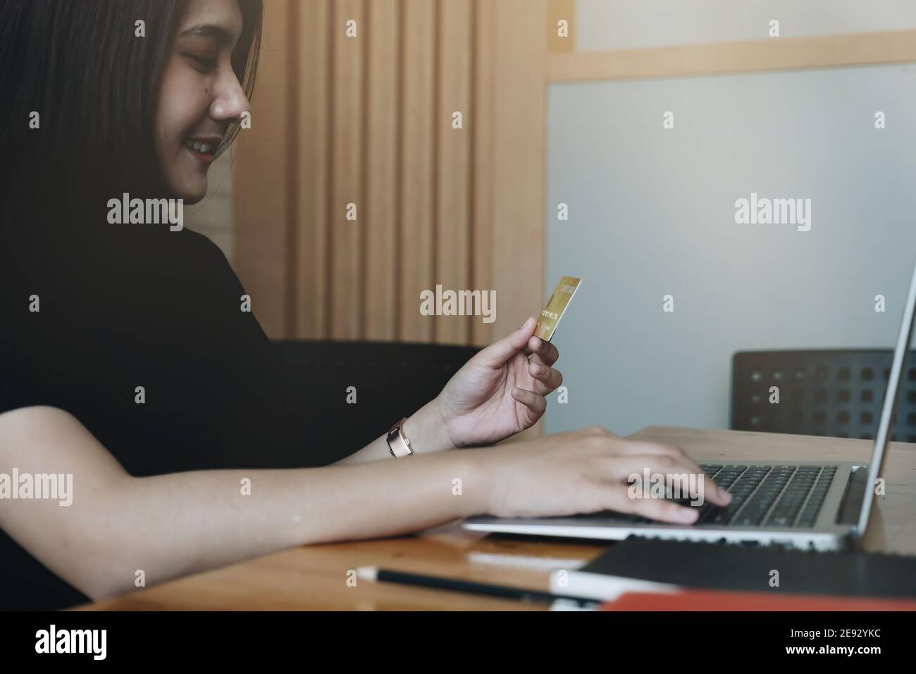 La mano di giovane donna che scrive sul laptop mentre fa lo shopping in linea, pagamento in linea. Foto Stock