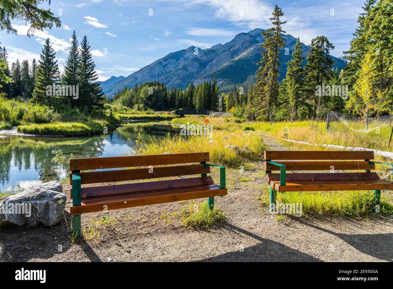 Panca in legno sul fiume Bow River. Percorso sul fiume Bow in estate. Monte Norquay sullo sfondo. Banff National Park, Canadian Rockies, Alberta, Foto Stock