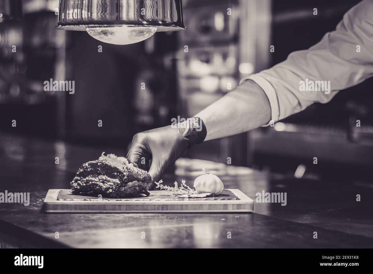 Chef che propone costolette grigliate su un bancone in un ristorante Foto Stock