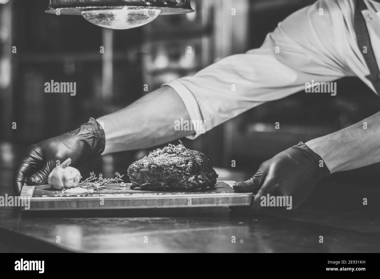Chef che propone costolette grigliate su un bancone in un ristorante Foto Stock