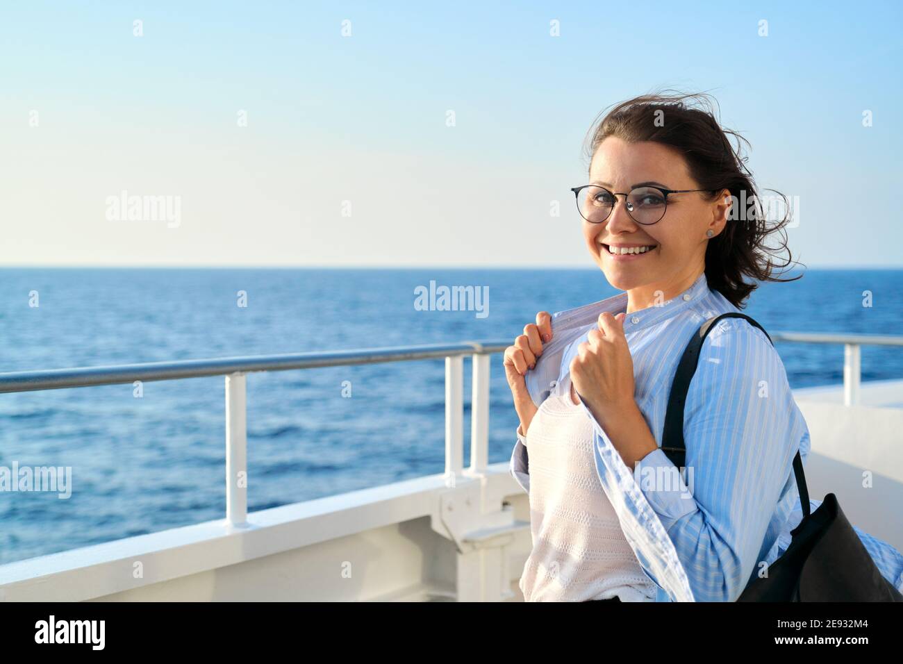 Felice donna di mezza età sul ponte della nave da crociera, copy space Foto Stock