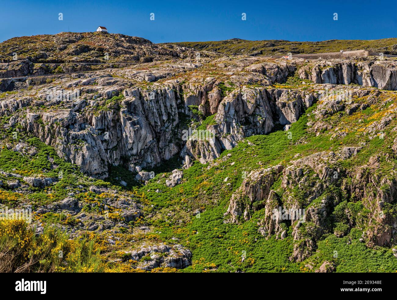 Ghiacciai, rocce di granito esposte da erosione glaciale, sul bacino idrico di Covao do Corral, capanna in lontananza, Parco Naturale Serra da Estrela, Portogallo Foto Stock
