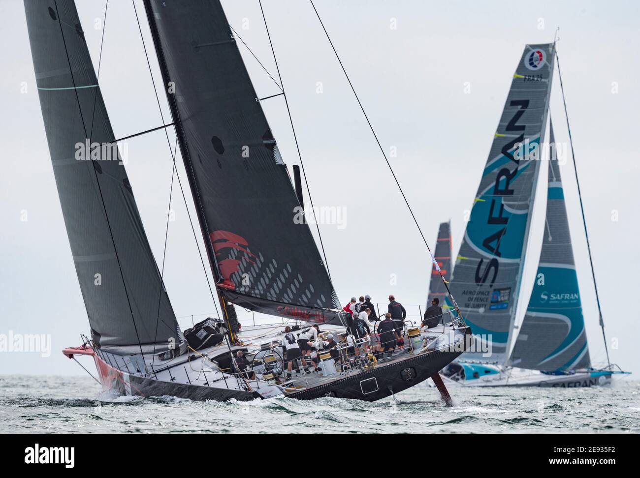 Lo yacht francese Safran e il monoscafo più grande della flotta, Comanche, all'inizio del 90° anniversario Rolex Fastnet Race on the Solent. Pictur Foto Stock