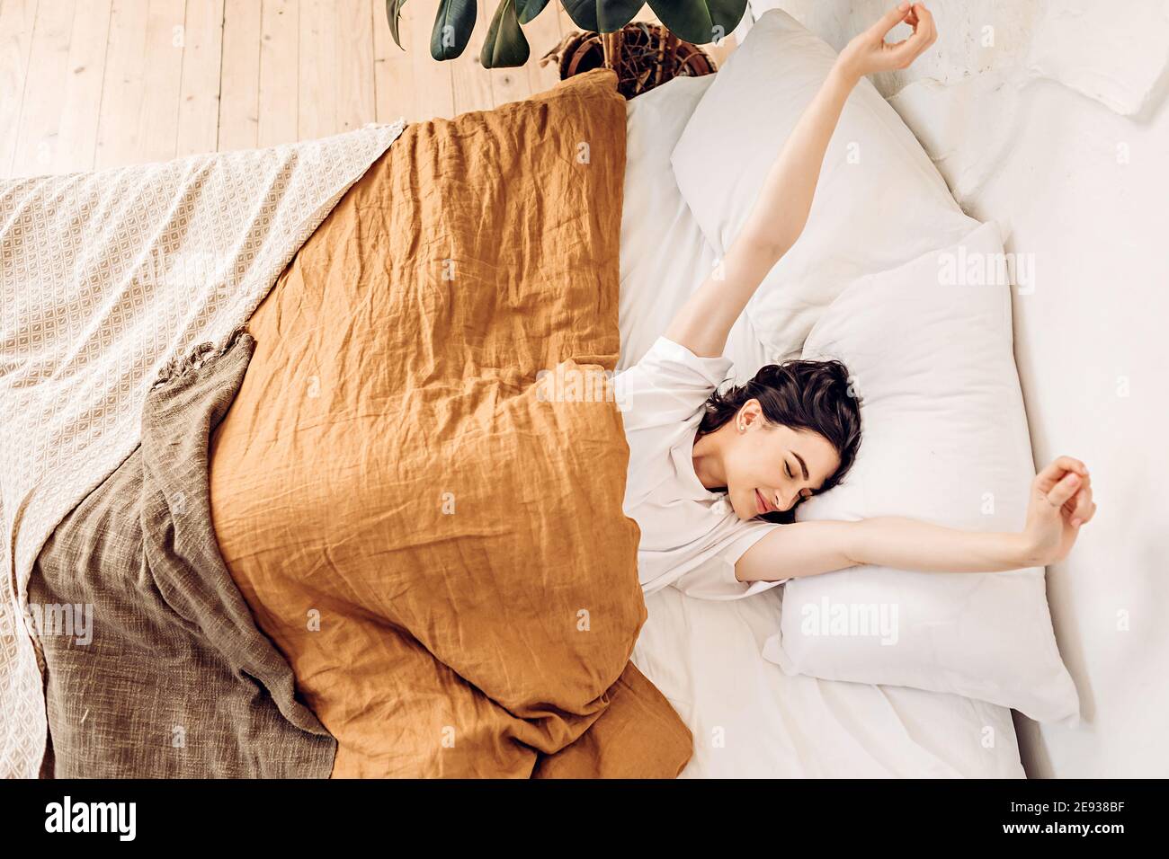 Ritratto di stile di vita di una giovane ragazza felice svegliarsi e. stendersi a letto la mattina presto Foto Stock