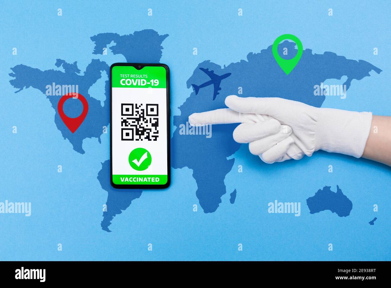 Portare il guanto sullo schermo del cellulare con passaporto elettronico di immunità con risultato del test COVID-19. Sfondo blu con mappa. Disposizione piatta. Concep Foto Stock