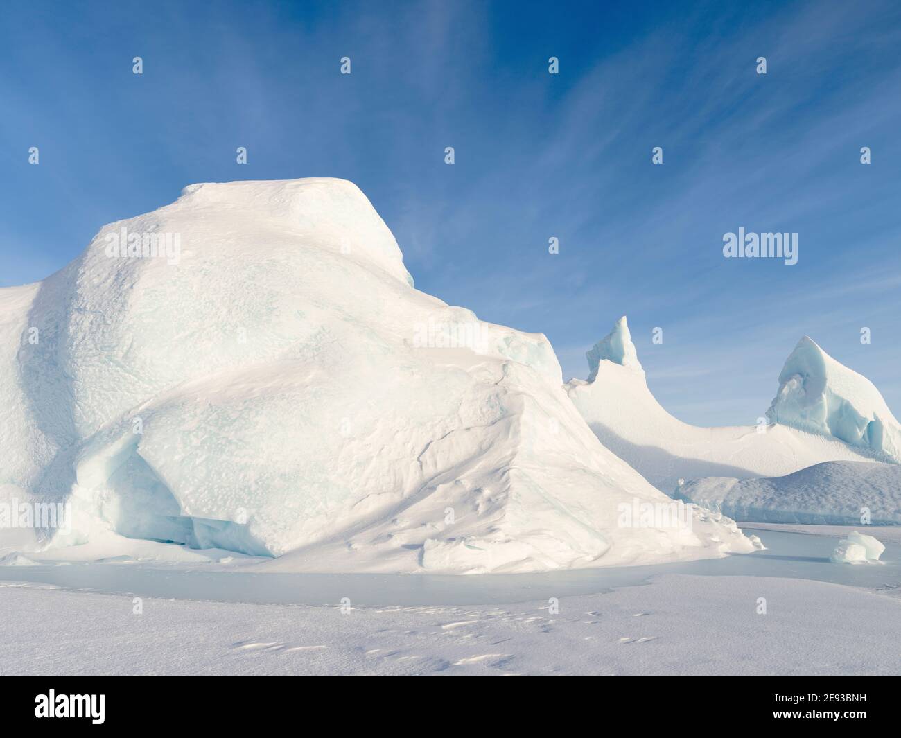 Iceberg congelato nel ghiaccio marino della Baia di Melville, parte della Baia di Baffin, vicino a Kullorsuaq, nell'estremo nord della Groenlandia occidentale. Foto Stock