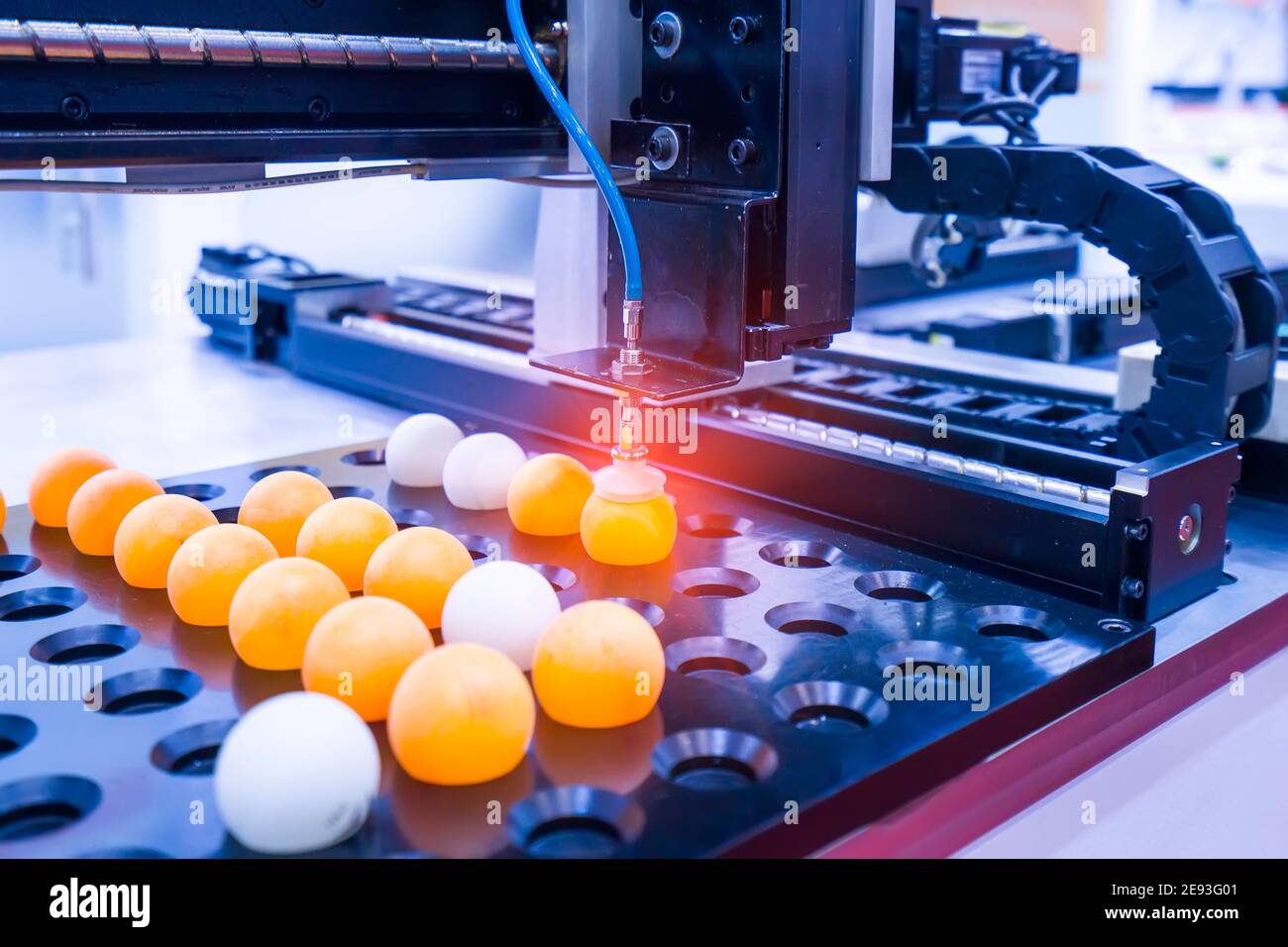 Il braccio robotico utilizzare con sistema a depressione per il contenimento di palla di ping-pong, industriale 4.0 technology per la moderna gestione della fabbrica. Foto Stock