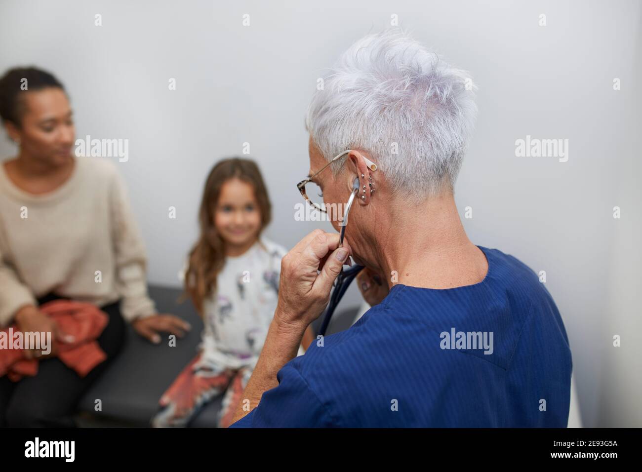Medico che esamina la ragazza nel centro di salute Foto Stock