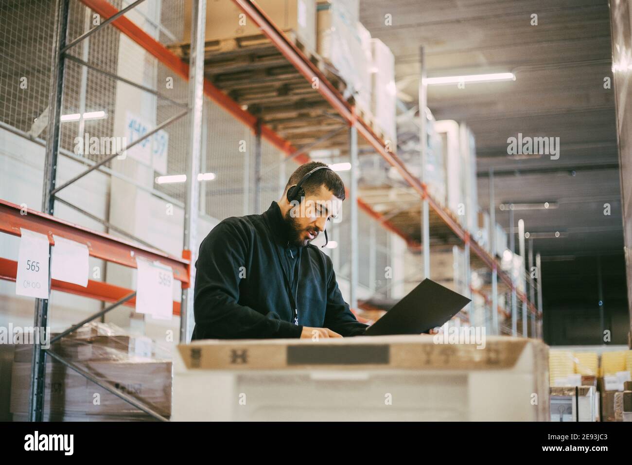 Uomo lavoratore manuale che legge il documento al magazzino logistico Foto Stock