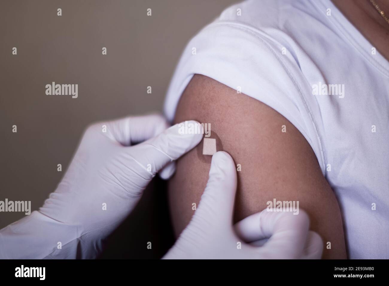Mettere l'aiuto di banda sul braccio dopo la vaccinazione Foto Stock