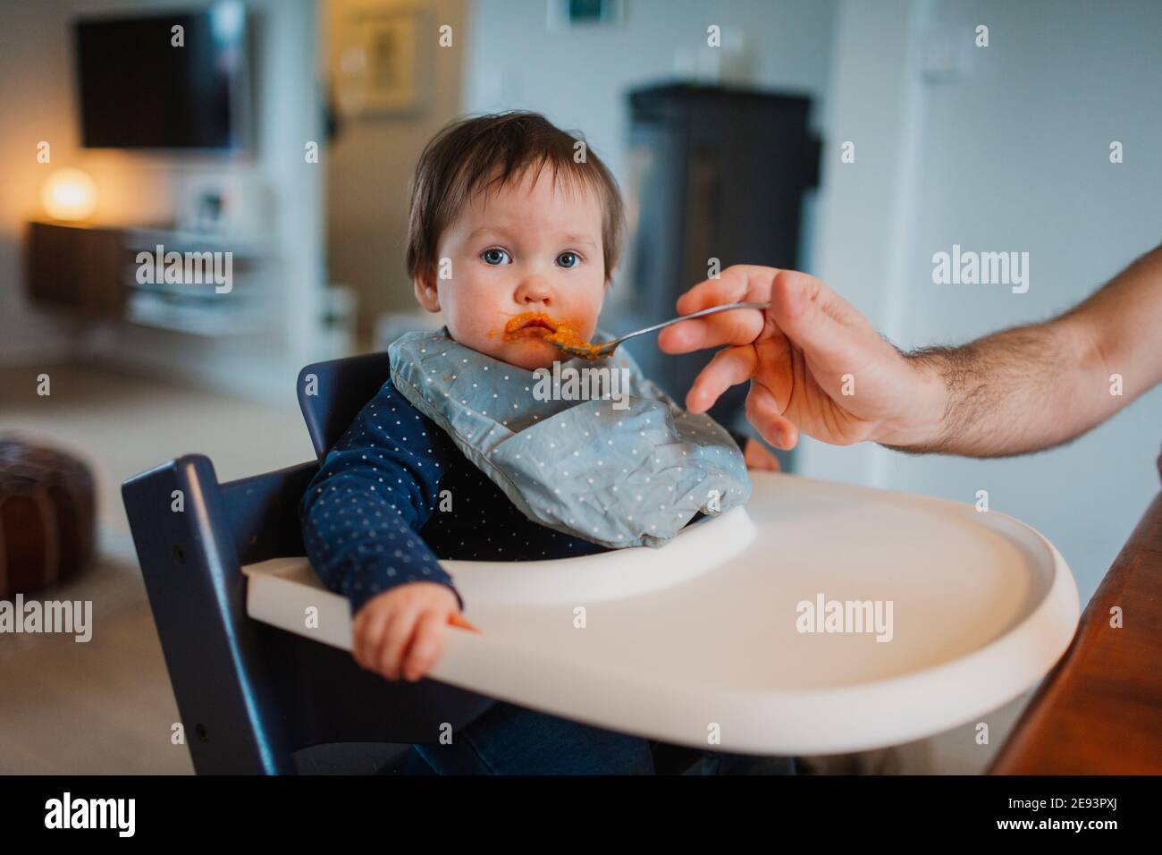 Bambino in seggiolone che viene nutrito Foto Stock