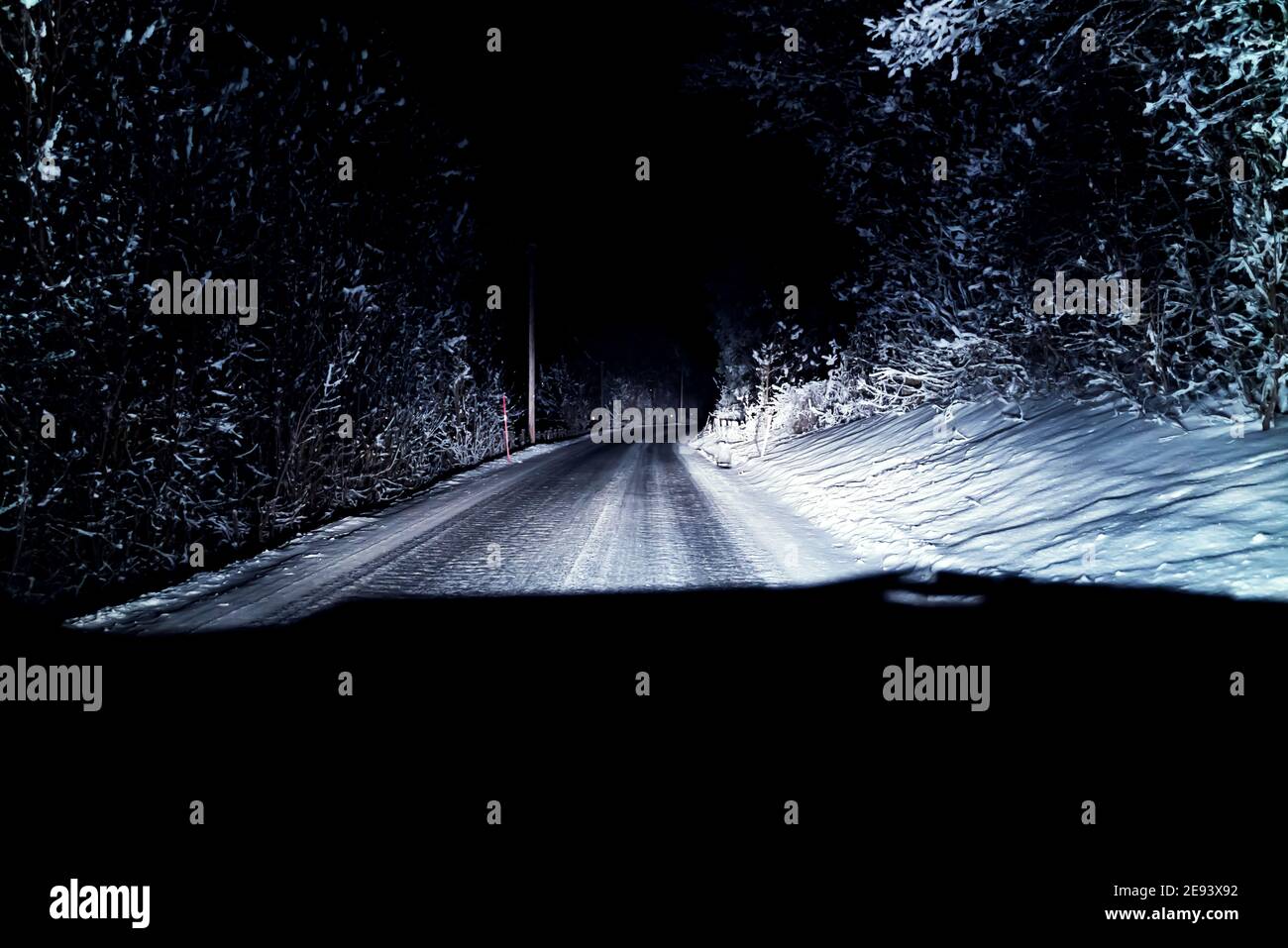 Auto che guida su una strada ghiacciata di notte durante l'inverno. Il punto di vista dei conducenti. Foto Stock