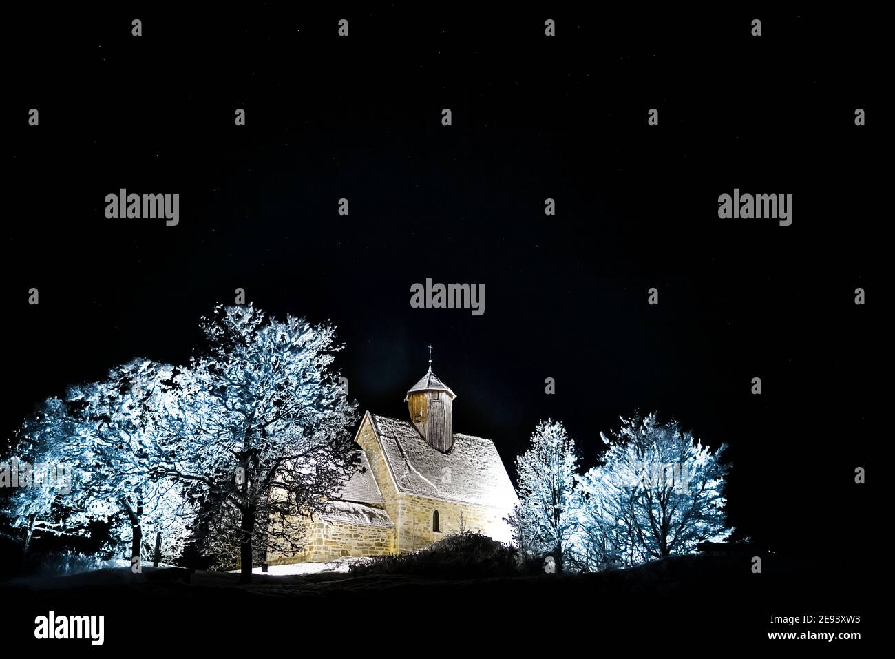 Vecchia chiesa medievale illuminata su una notte stellata inverni. Foto Stock
