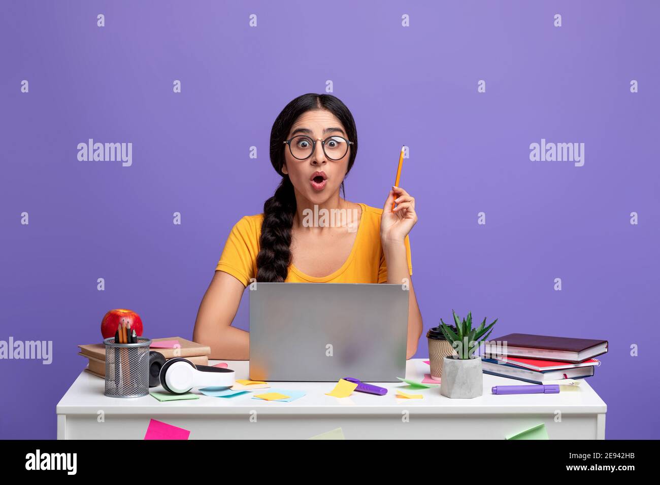 Concetto di idea. Donna indiana eccitata in Eyeglasses alzando la matita in su Foto Stock