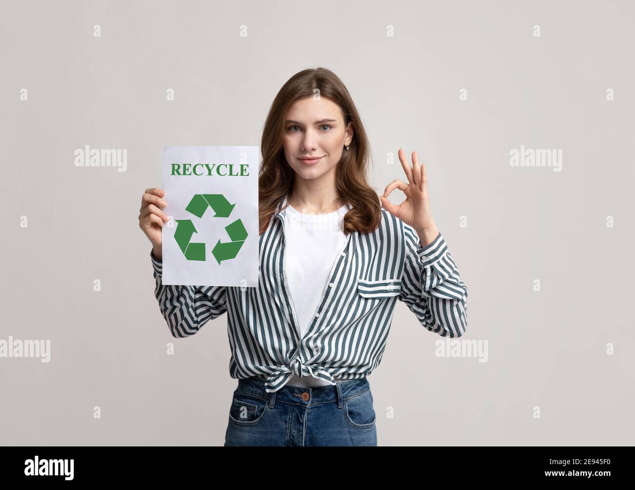 Cartello Motivazionale Smiling Lady Holding con cartello riciclabile e mostra OK Gesture Foto Stock