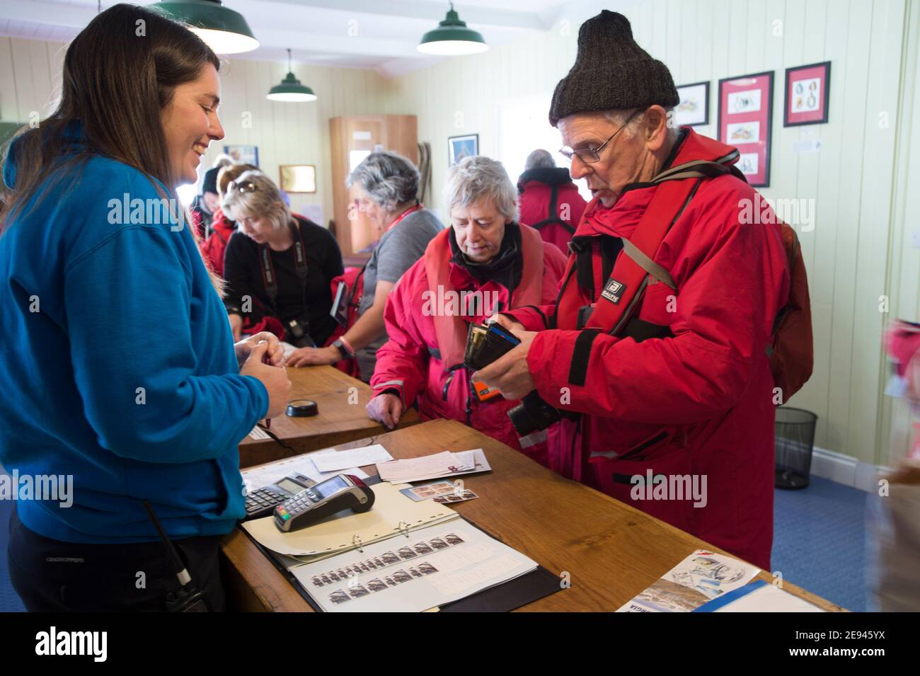 Lavoratore di uffici postali secondario che serve i clienti nell'ufficio postale di Grytviken, nell'isola della Georgia del Sud, Antartide Foto Stock