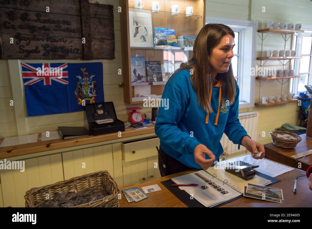 Lavoratore di uffici postali secondario che serve i clienti nell'ufficio postale di Grytviken, nell'isola della Georgia del Sud, Antartide Foto Stock