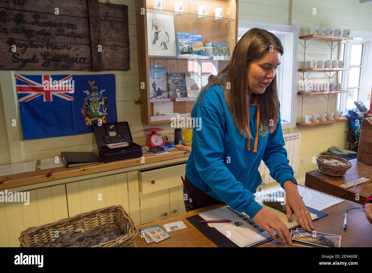 Lavoratore di uffici postali secondario che serve i clienti nell'ufficio postale di Grytviken, nell'isola della Georgia del Sud, Antartide Foto Stock