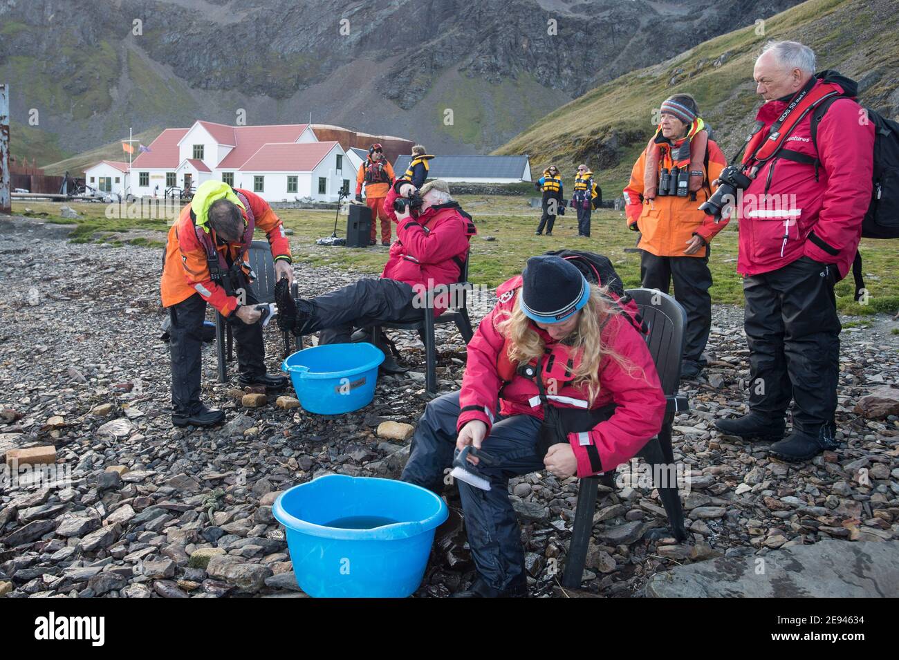 I turisti a Grytviken sulla georgia meridionale scarponi puliti la spiaggia per motivi di bio-sicurezza Foto Stock