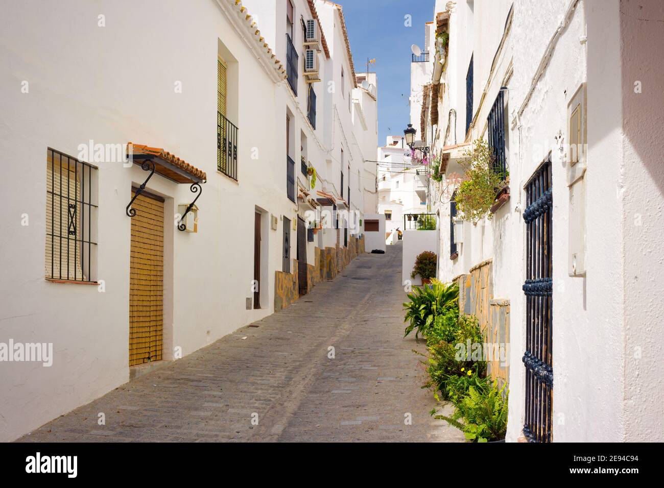 Vista di una strada che sorge nella zona superiore del centro storico di ​​the Casares, con le sue stradine strette e le case bianche. Casares, Andalusia, Foto Stock