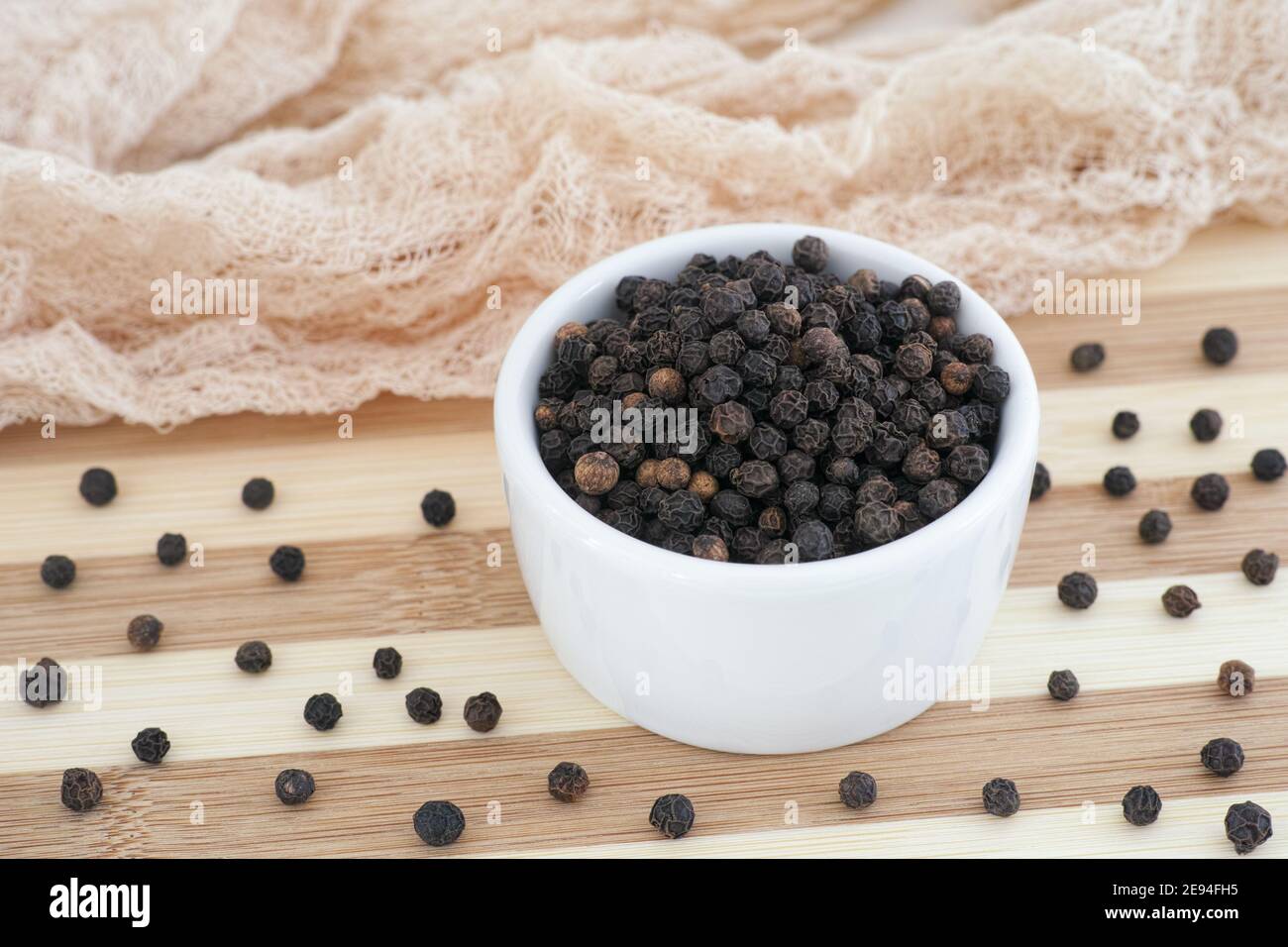 Pepe nero intero organico in una ciotola bianca. Primo piano. Foto Stock