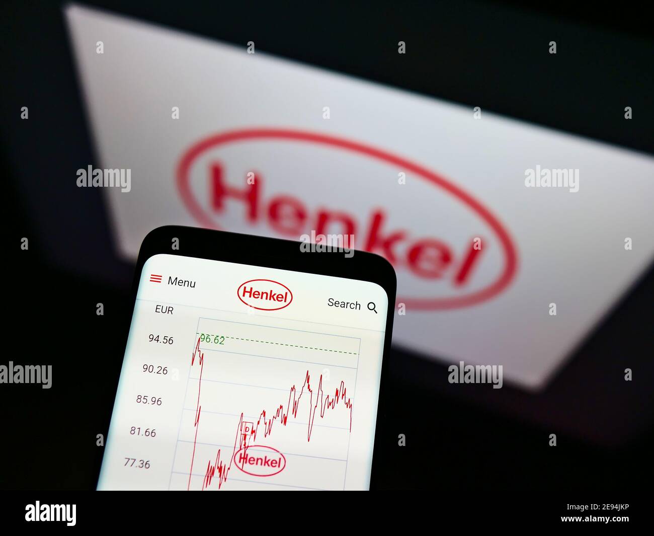 Telefono cellulare con tabella dei prezzi in stock della società tedesca di prodotti chimici e di consumo Henkel in esposizione con il logo. Mettere a fuoco nella parte superiore centrale dello schermo del telefono. Foto Stock
