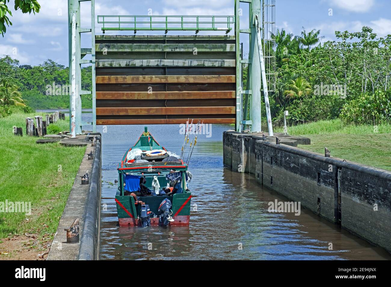 Piccola barca tradizionale di pesca in legno che lascia la serratura / chiusa sul fiume Saramacca al villaggio di Uitkijk, Saramacca Distretto, Suriname / Surinam Foto Stock