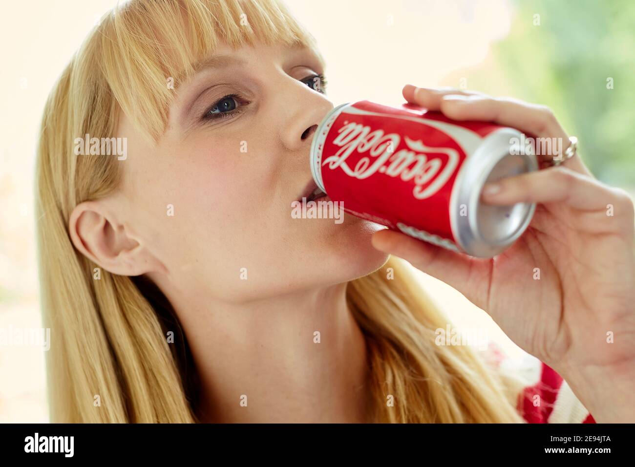 Donna che beve coke da una lattina Foto Stock