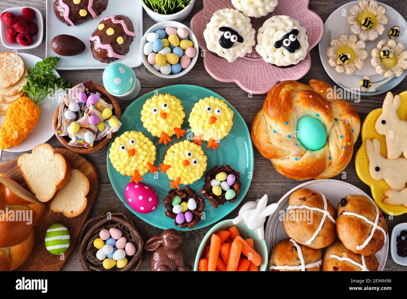 Tavola pasquale con un assortimento di pane, dessert e prelibatezze. Vista dall'alto su uno sfondo di legno. Concetto di cibo per le vacanze primaverili. Foto Stock